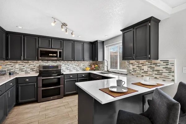 a kitchen with a sink stove and microwave