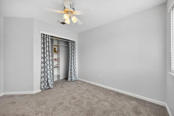 an empty room with chandelier fan
