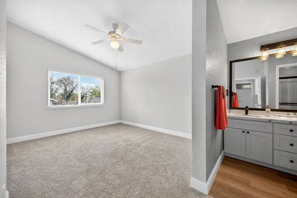 a view of an empty room with window and wooden floor