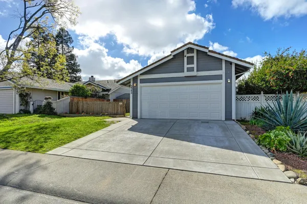 a front view of house with a yard and green space