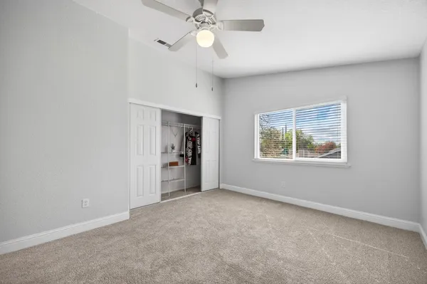 an empty room with fan and windows
