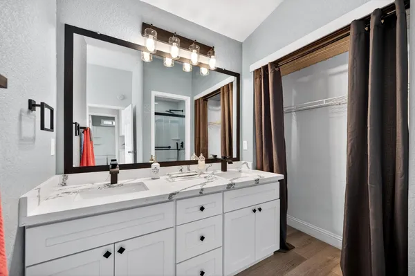 a bathroom with a double vanity sink and a mirror