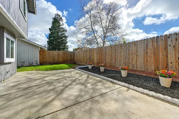 a view of a backyard with table and chairs and wooden fence
