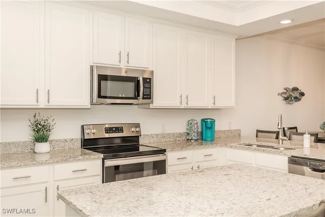a kitchen with stainless steel appliances kitchen island granite countertop a sink a stove and a microwave