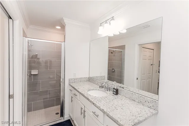 a bathroom with a granite countertop sink a shower and a mirror