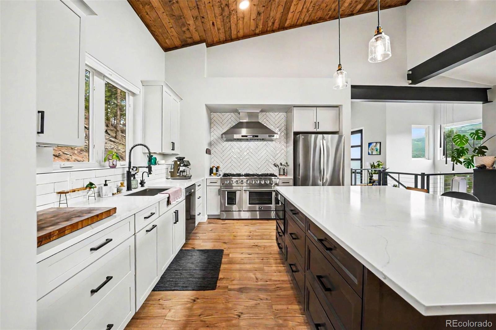 7231 Timber Trail Road Evergreen, CO 80439 - Photo 6 of 35 a large kitchen with stainless steel appliances granite countertop a lot of counter space and wooden floor