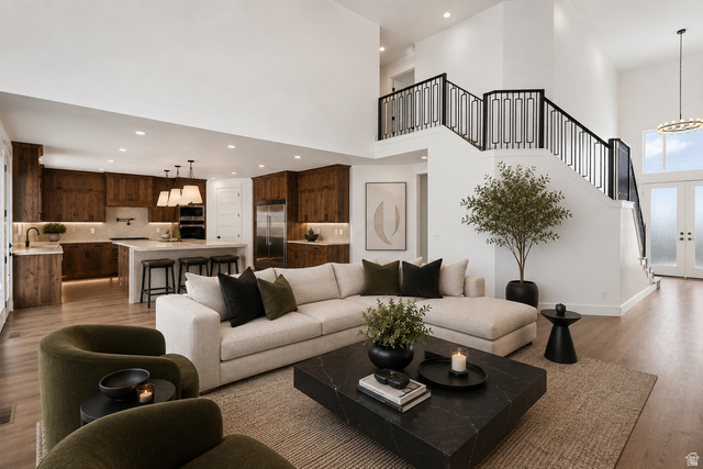 692 East Mountain Road North Ogden, UT 84414 - Photo 7 of 35 Vaulted great room with wood-finish flooring and a contemporary open-tread staircase featuring a geometric metal railing