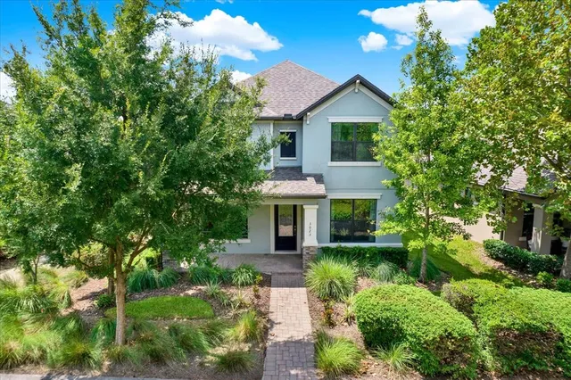 a front view of a house with a yard and potted plants