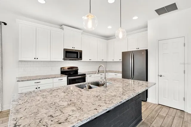 a kitchen with stainless steel appliances granite countertop a sink refrigerator and microwave