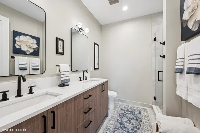 a bathroom with double vanity and a mirror