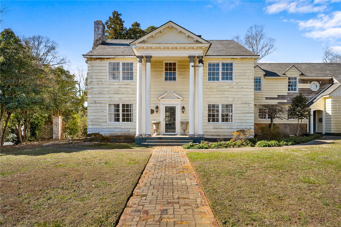 Grand estate with a classic facade awaits your vision.