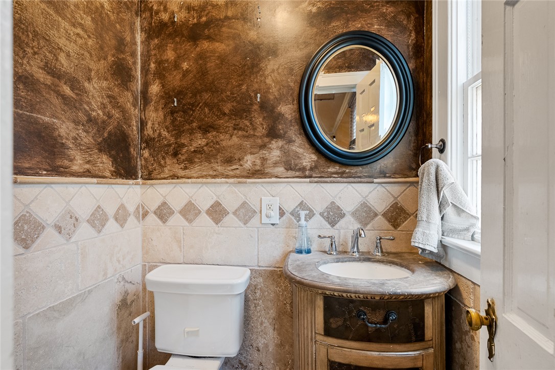 2307 North Avenue Anderson, SC 29625 - Photo 18 of 49 This powder room features detailed tile work, a vanity with an integrated sink, and a framed mirror.
