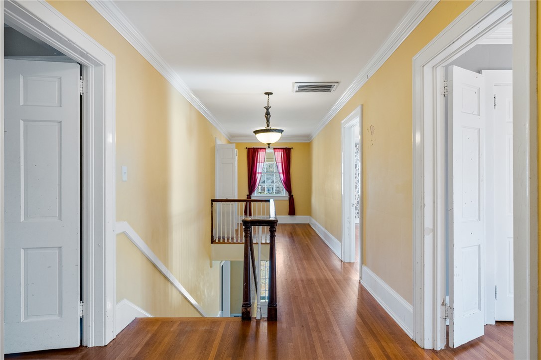 2307 North Avenue Anderson, SC 29625 - Photo 29 of 49 This spacious hallway features polished hardwood floors and classic crown molding, leading to bright living areas.