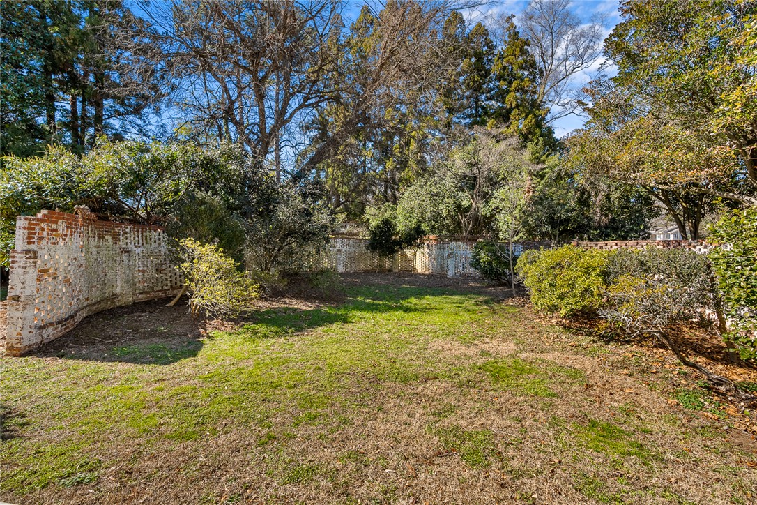 2307 North Avenue Anderson, SC 29625 - Photo 47 of 49 This private yard features mature trees and a charming brick fence, offering a serene outdoor retreat.