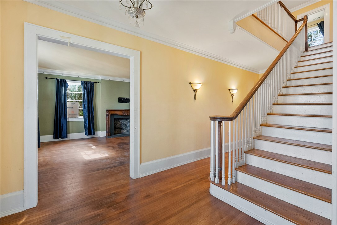 2307 North Avenue Anderson, SC 29625 - Photo 7 of 49 This inviting entrance features rich hardwood floors, a grand staircase, and a cozy fireplace in the adjacent room.