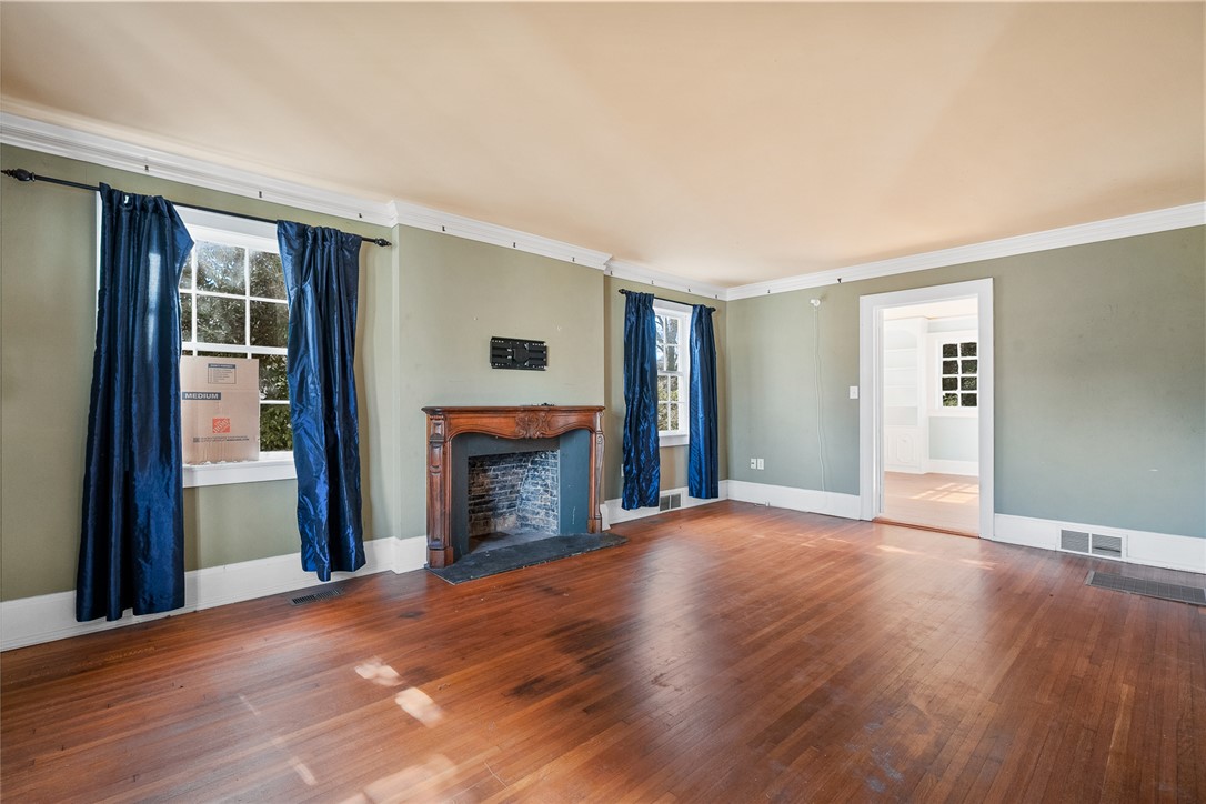 2307 North Avenue Anderson, SC 29625 - Photo 8 of 49 This inviting living area features warm wood flooring and a classic fireplace, perfect for cozy gatherings.