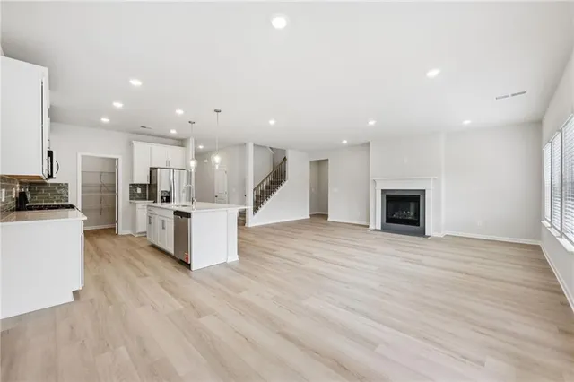 a kitchen with stainless steel appliances granite countertop a table and chairs in it