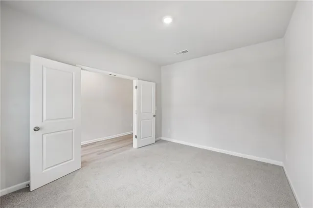 a spacious bedroom with a bed a couch and large window