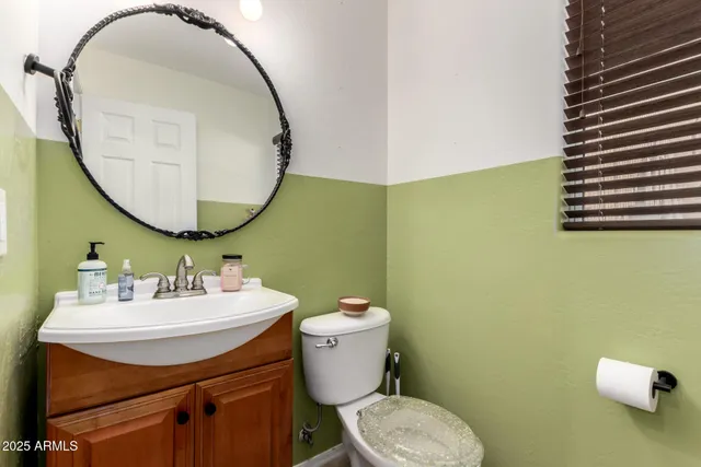 a bathroom with a sink mirror and toilet
