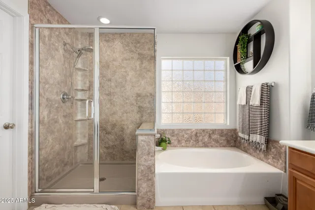 a bathroom with a bathtub a shower and a window