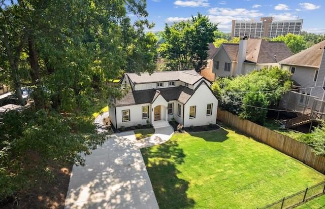 a front view of a house with a yard and large trees