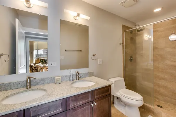 a bathroom with a granite countertop sink toilet and shower