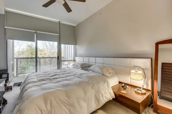 a bedroom with a bed and large window