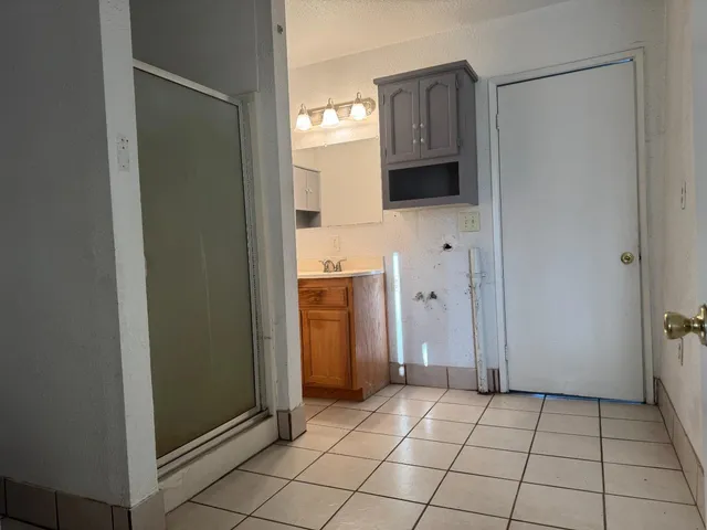 a view of a utility room with closet and mirror