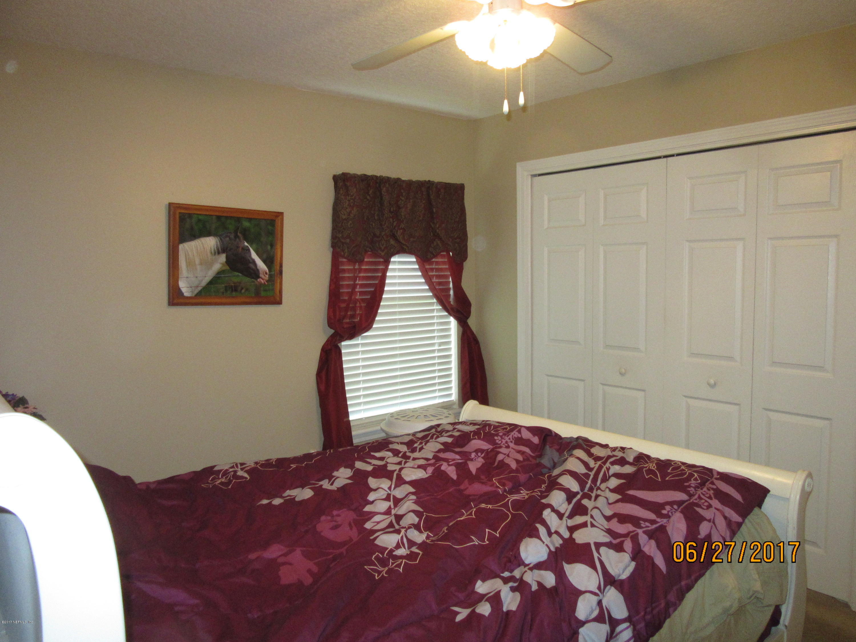 766 East Red House Branch Road St. Augustine, FL 32084 - Photo 11 of 15 a bedroom with a bed and a painting on the wall