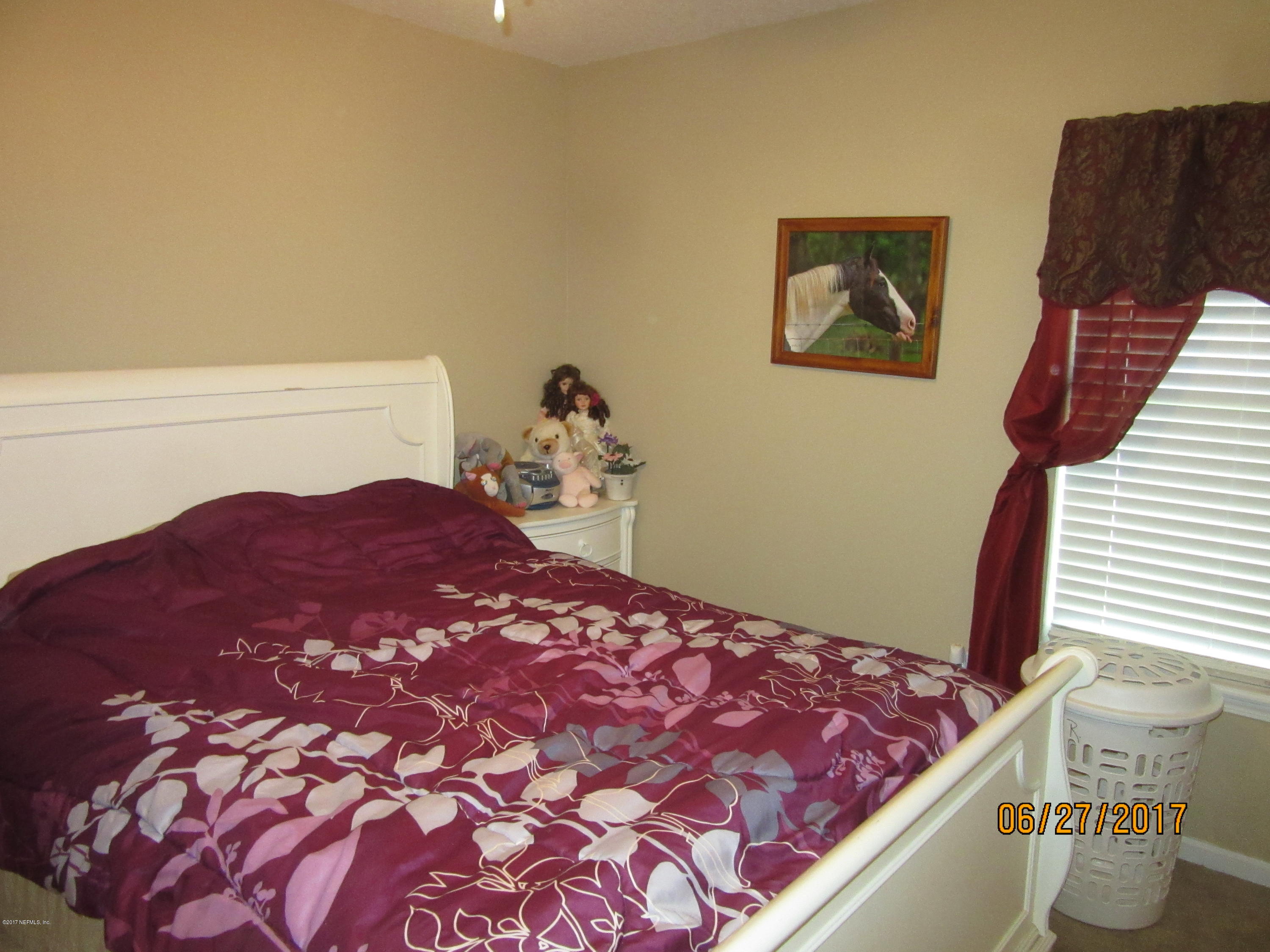 766 East Red House Branch Road St. Augustine, FL 32084 - Photo 13 of 15 a bedroom with a bed and a window