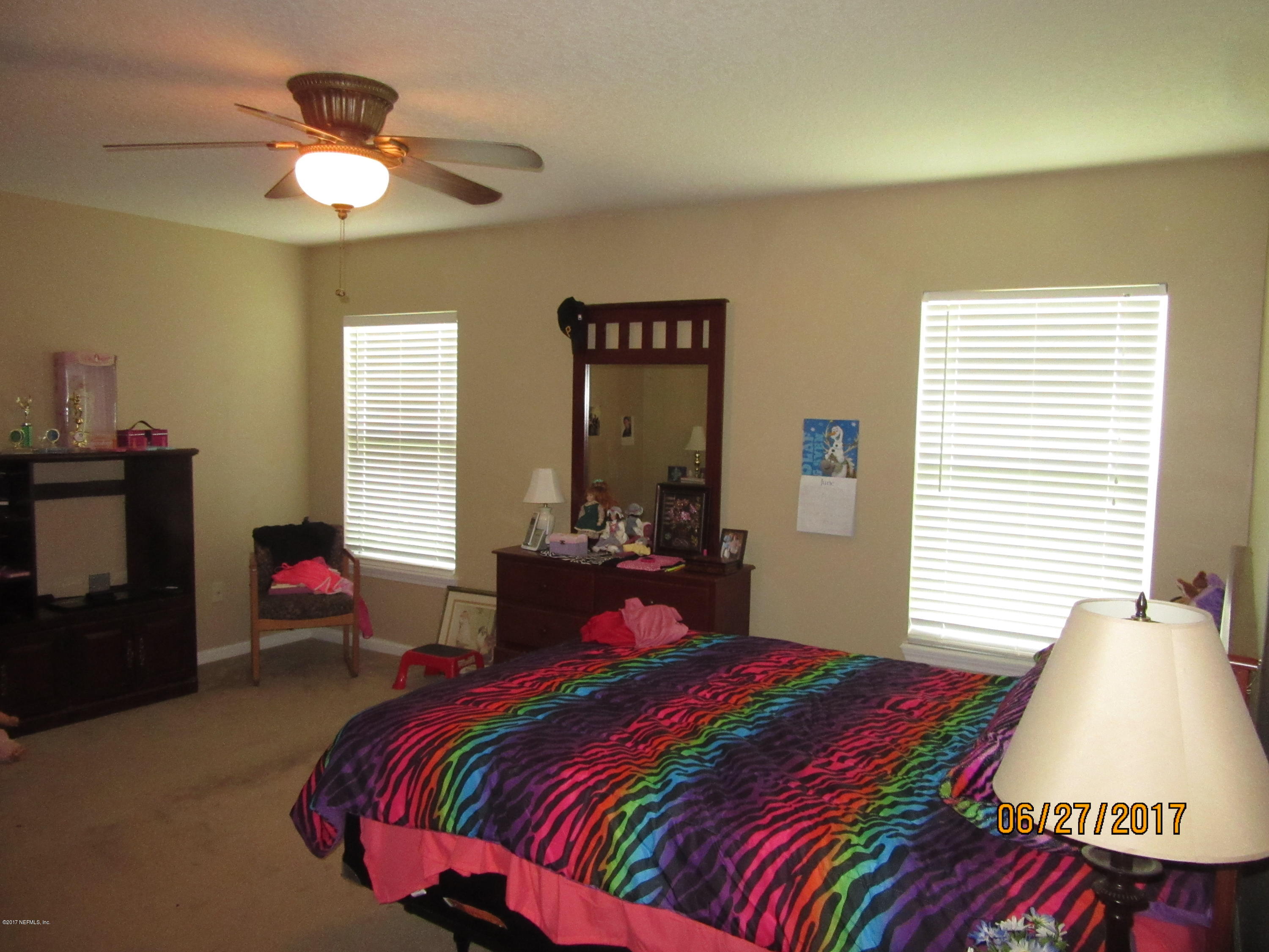 766 East Red House Branch Road St. Augustine, FL 32084 - Photo 10 of 15 a bedroom with a bed and a chandelier