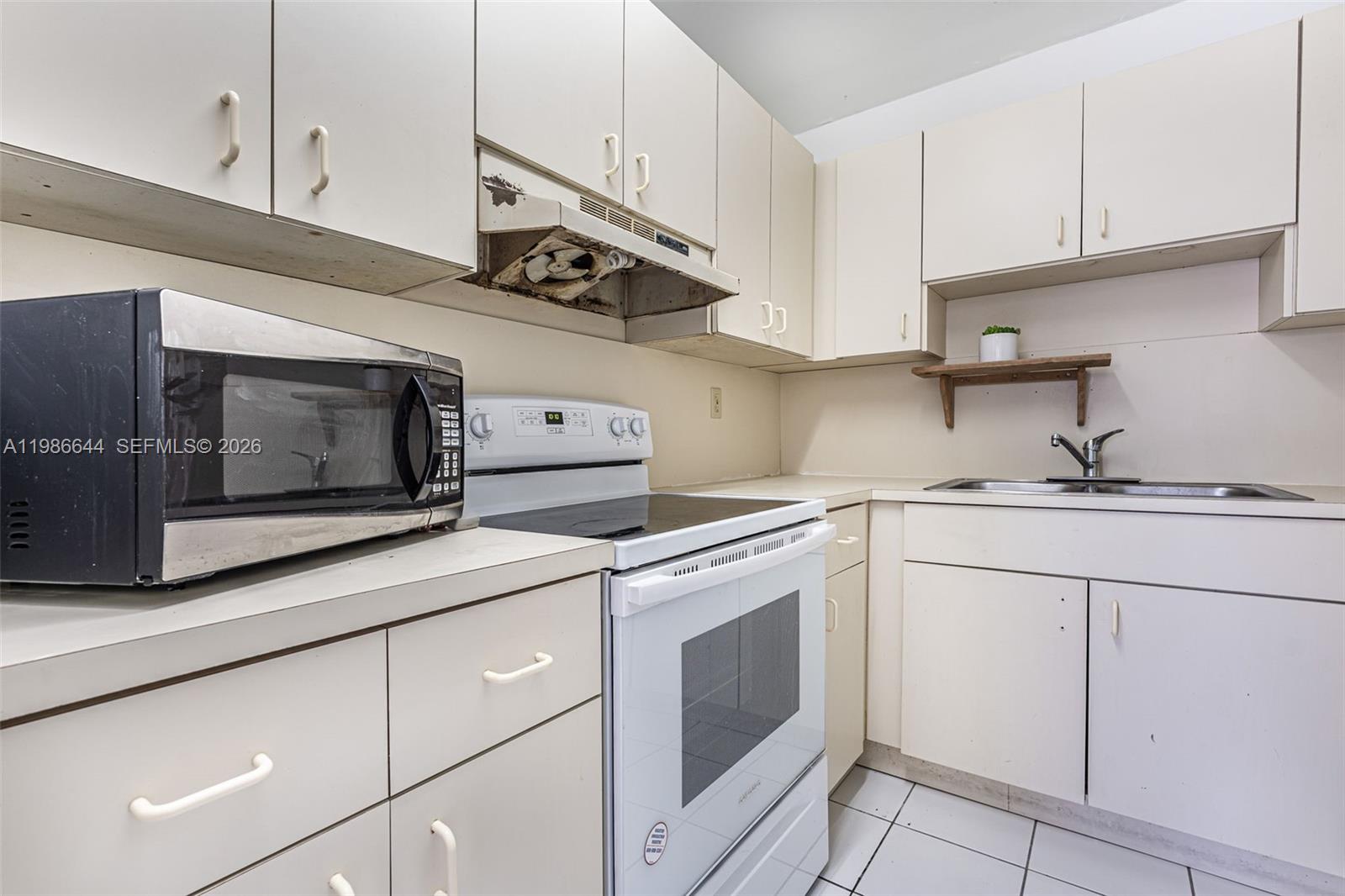 15260 Southwest 80th Street, Unit 10 Miami, FL 33193 - Photo 15 of 27 a kitchen with cabinets stainless steel appliances and wooden floor