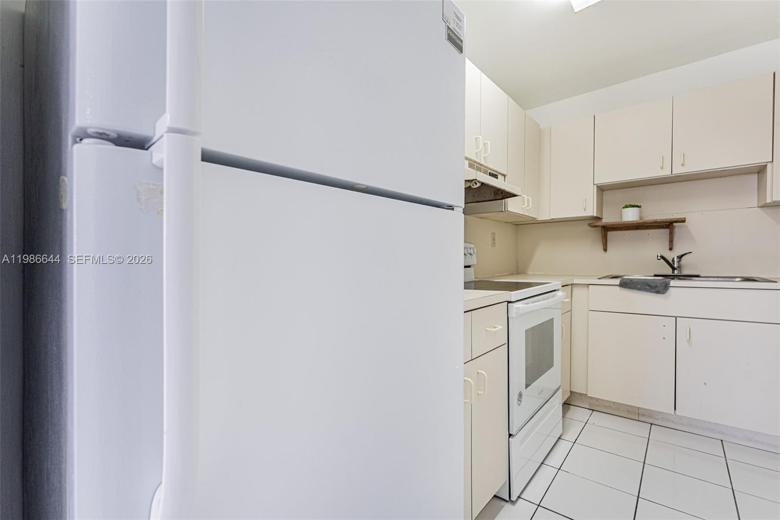 15260 Southwest 80th Street, Unit 10 Miami, FL 33193 - Photo 17 of 27 a kitchen with white cabinets and white appliances