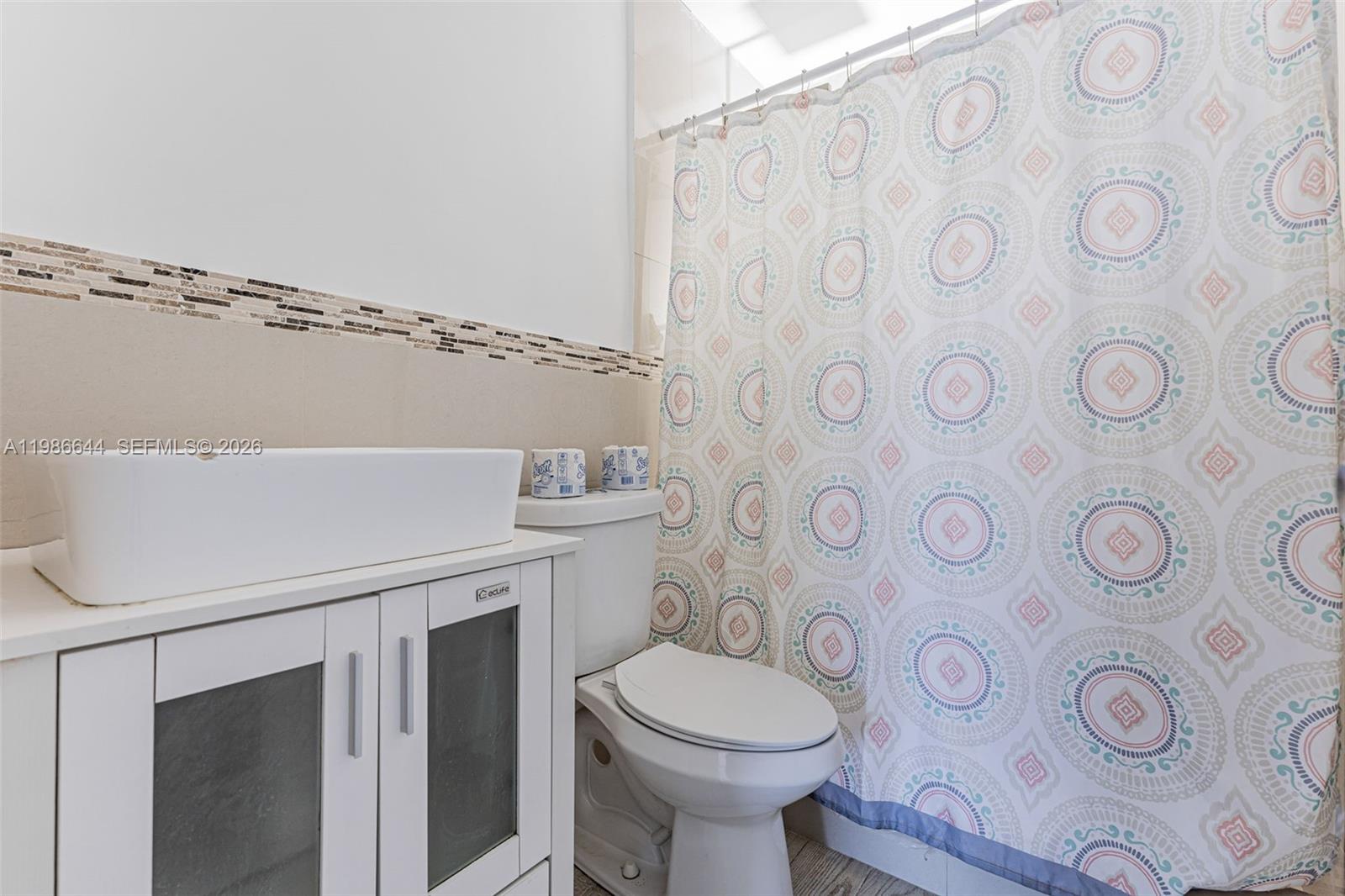 15260 Southwest 80th Street, Unit 10 Miami, FL 33193 - Photo 26 of 27 a bathroom with a toilet a sink and a shower curtain