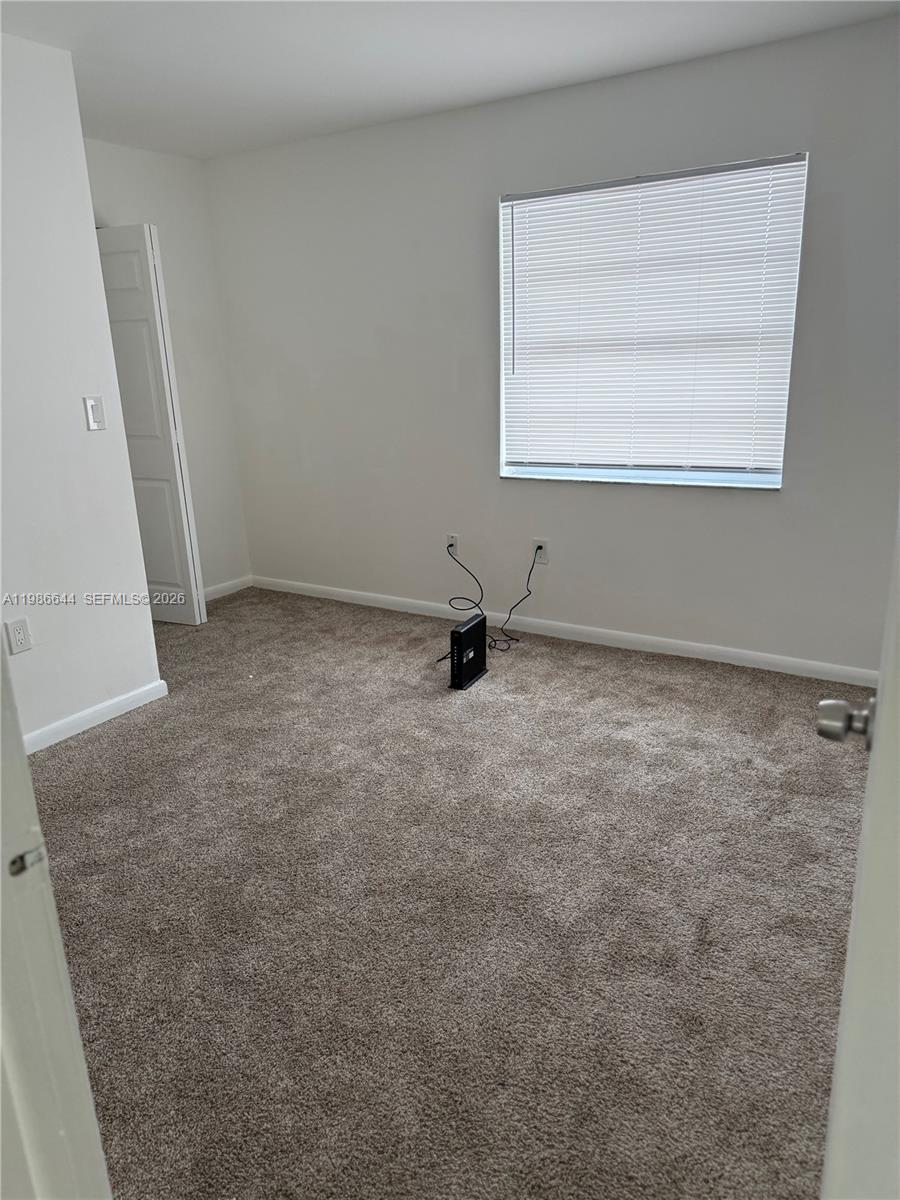 15260 Southwest 80th Street, Unit 10 Miami, FL 33193 - Photo 4 of 27 an empty room with a window