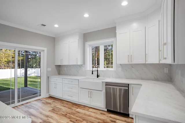 a kitchen with white cabinets and sink