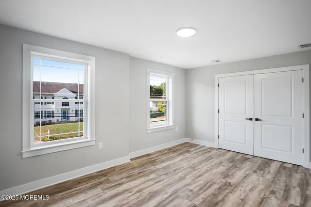a view of empty room with wooden floor and ceiling fan