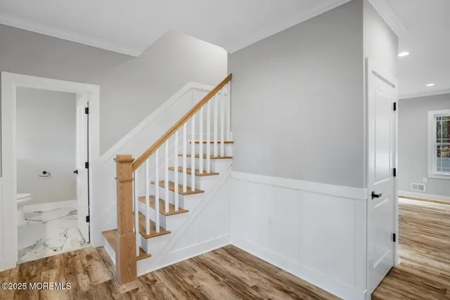 a view of a livingroom with a chandelier fan and wooden floor