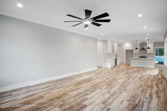 a large white kitchen with stainless steel appliances kitchen island a stove a refrigerator a table and chairs