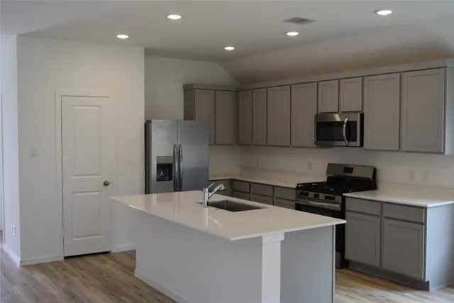 a kitchen with a refrigerator and a stove top oven