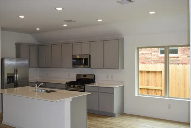 a kitchen with kitchen island a sink stainless steel appliances and window