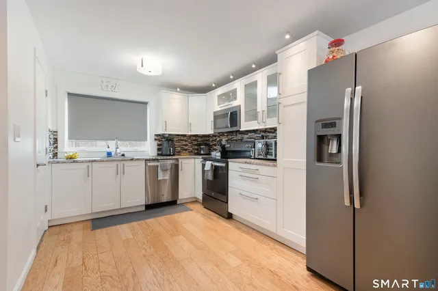 a kitchen with stainless steel appliances a refrigerator sink and microwave