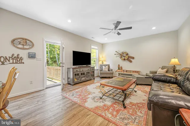 a kitchen with granite countertop a white refrigerator oven a sink dishwasher and white cabinets with wooden floor