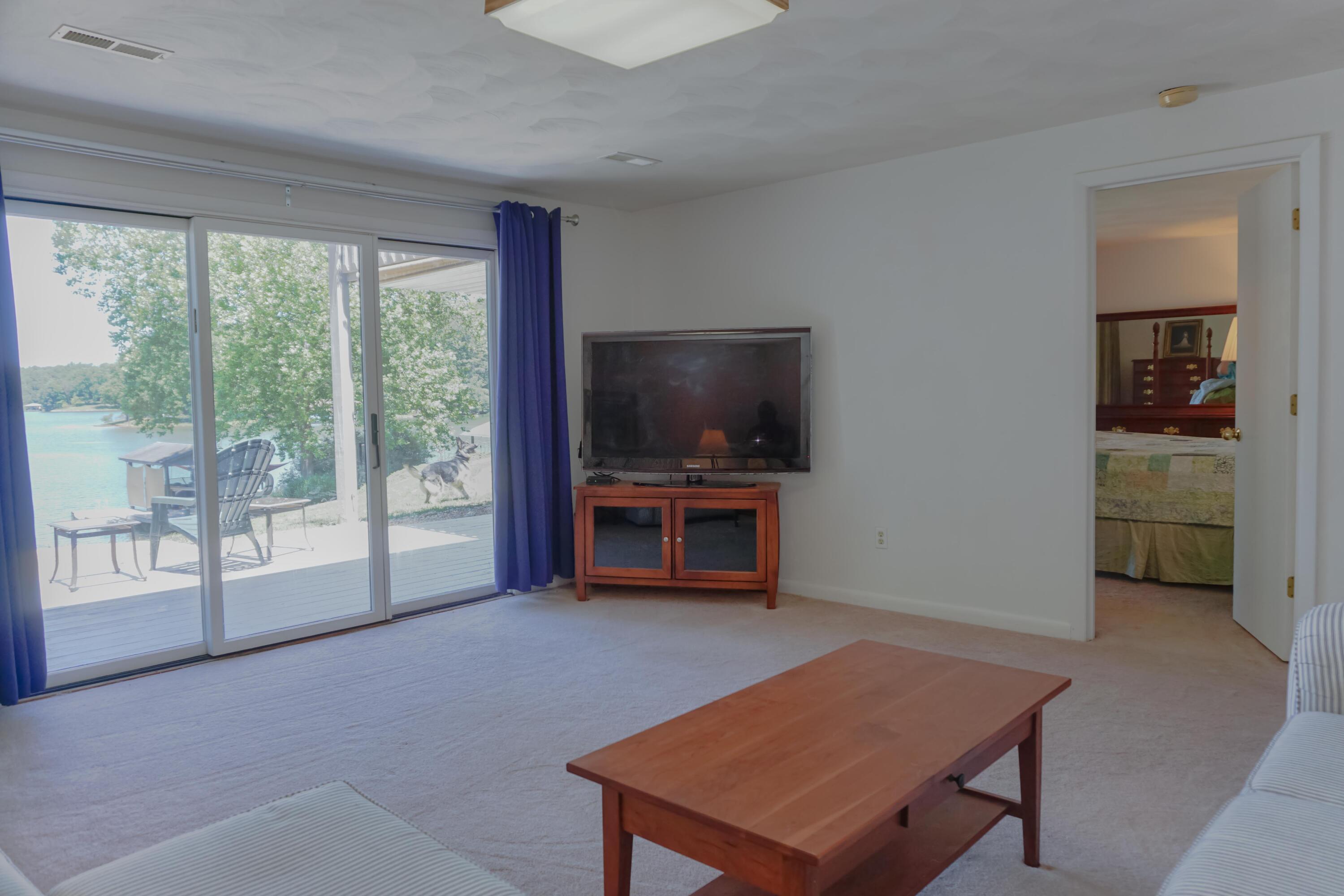 497 Cedar Ridge Road Union Hall, VA 24176 - Photo 19 of 31 a living room with furniture a flat screen tv and a floor to ceiling window
