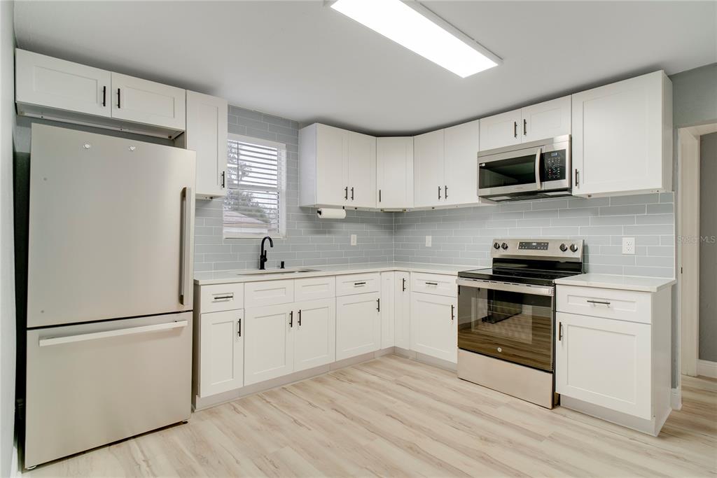 330 East Story Road Winter Garden, FL 34787 - Photo 6 of 21 a kitchen with granite countertop white cabinets and stainless steel appliances