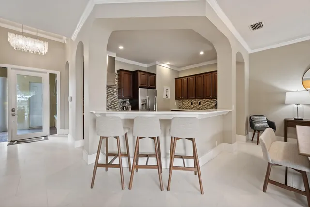 a kitchen with stainless steel appliances kitchen island granite countertop a table chairs sink and cabinets