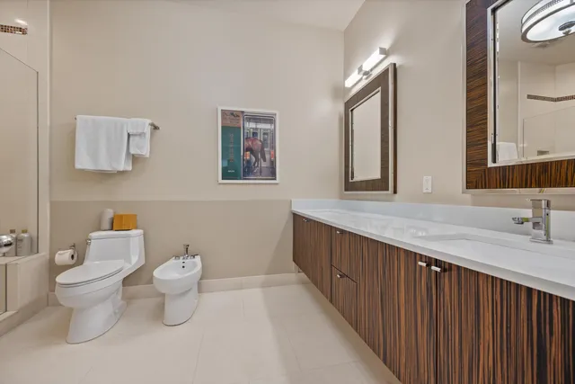 a bathroom with a granite countertop toilet a sink and a large mirror