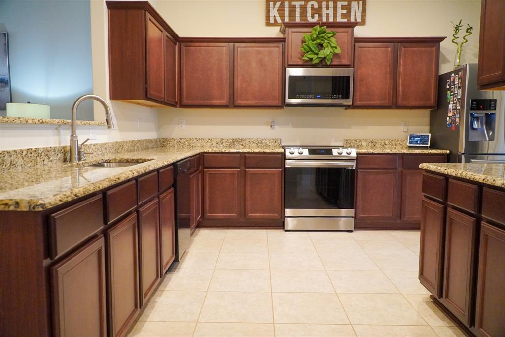 13624 Helix Bridge Way Crowley, TX 76036 - Photo 8 of 25 a kitchen with stainless steel appliances granite countertop a stove microwave and sink