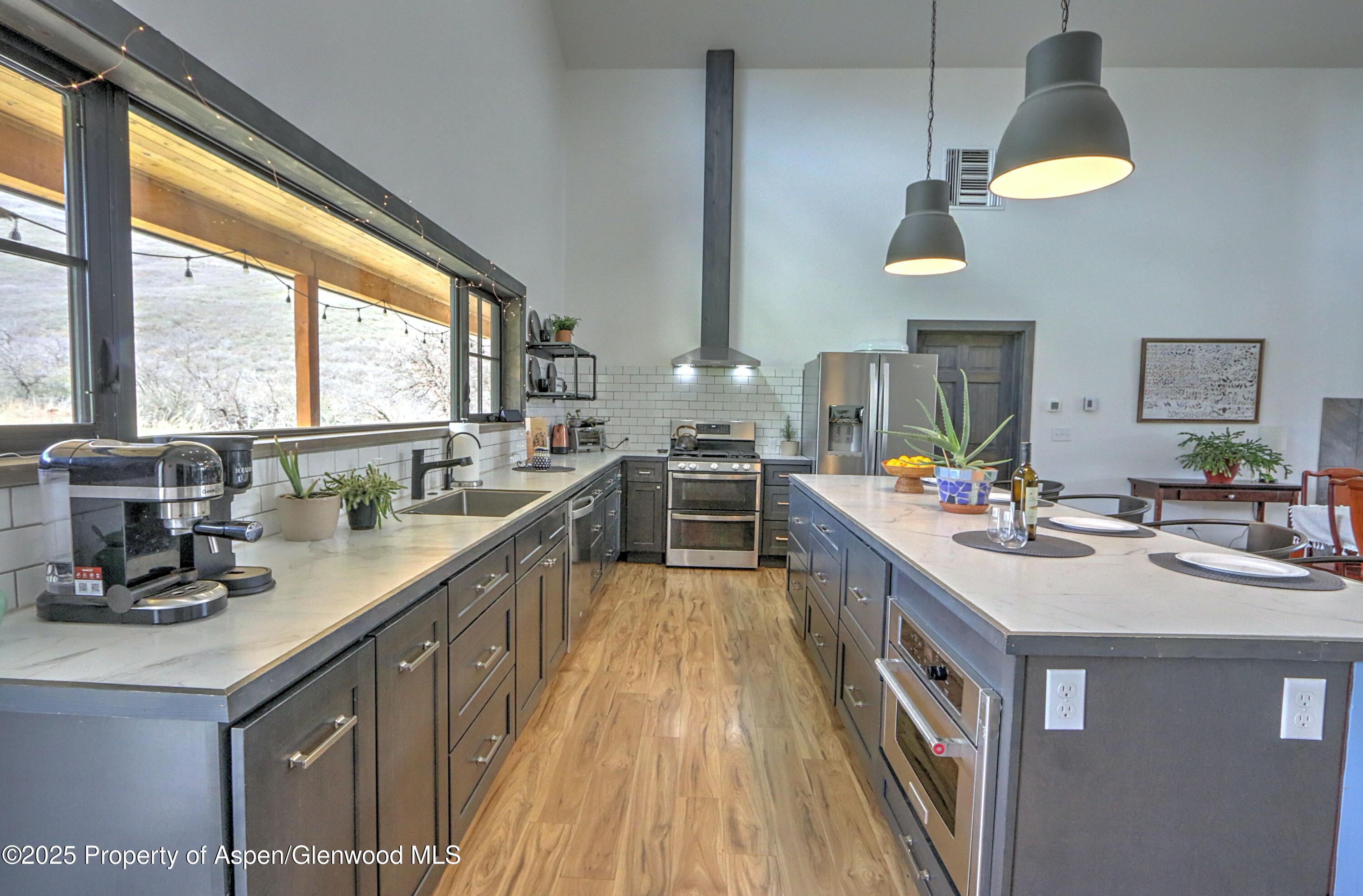 7315 County Road 312 New Castle, CO 81647 - Photo 11 of 75 a kitchen with kitchen island granite countertop a sink appliances cabinets and a large window