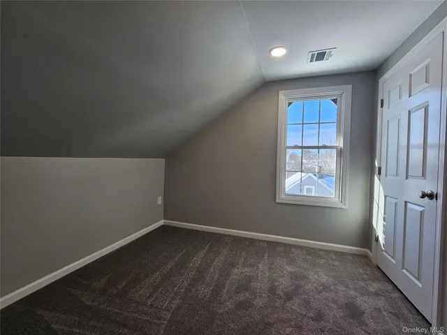 an empty room with windows and cabinet